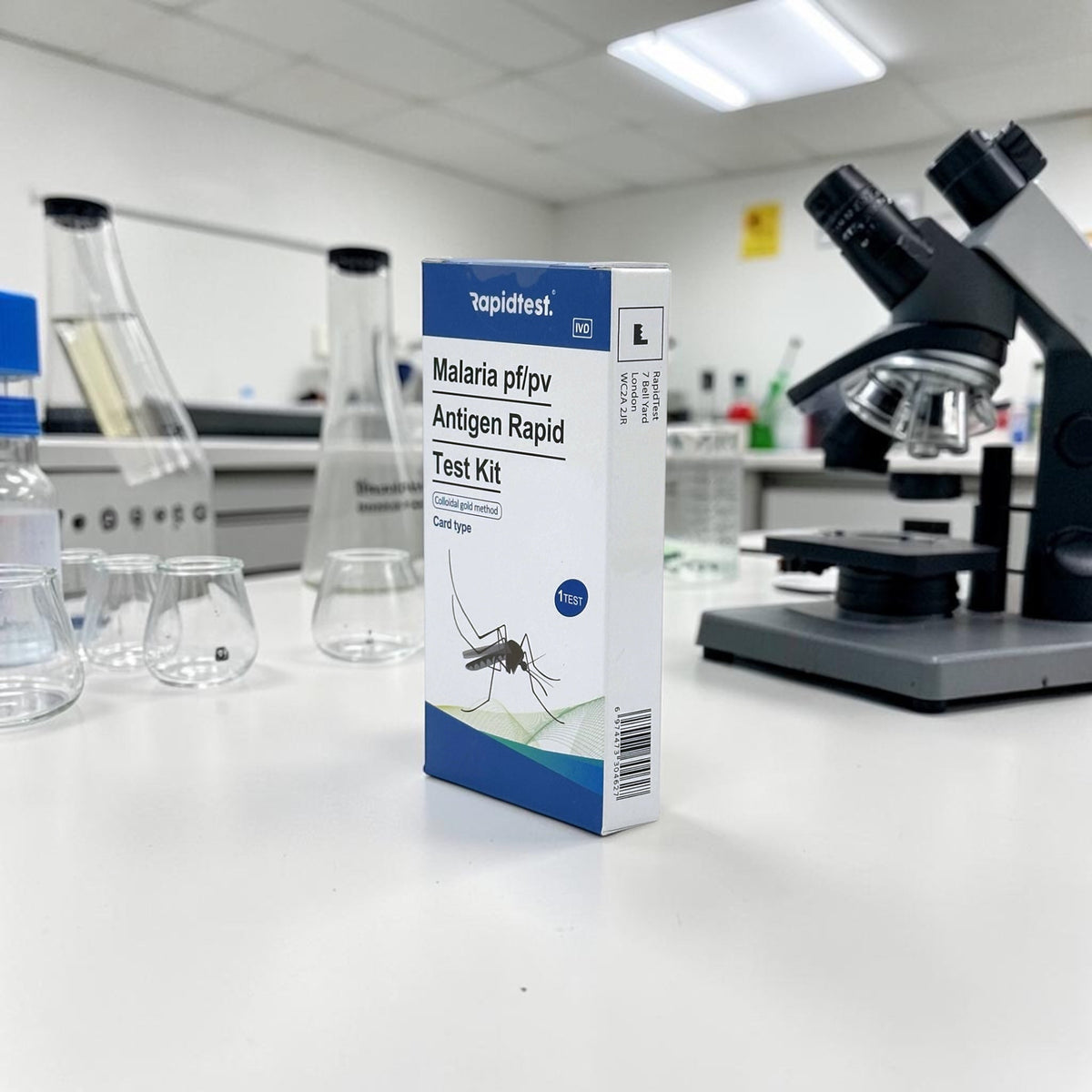 Malaria test kit box on a laboratory counter with a microscope in the background - STIhealthcheck.com