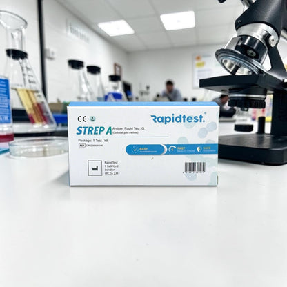 Rapidtest STREP A antigen rapid test kit box in a laboratory setting with a microscope and lab equipment.